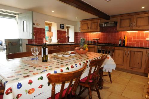 a kitchen with a table with a table cloth on it at Church Cottage in Charmouth
