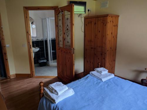 a bedroom with a blue bed with towels on it at Lough Gara Lodge Self Catering in Gorteen