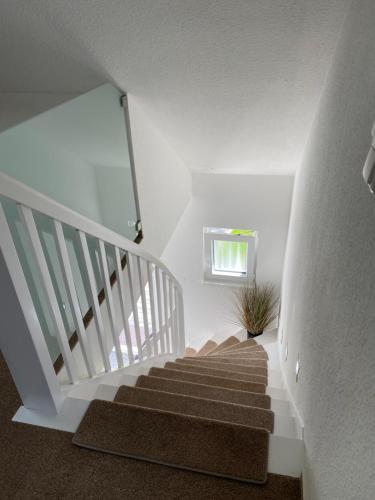 a staircase in a house with a white stair case at Luxuriöses Ferienhaus Anita nahe Timmendorfer Strand, Travemünde und Lübeck in Sereetz
