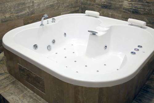a large white bath tub in a bathroom at Piccolo di Piazza di Spagna Suites in Rome