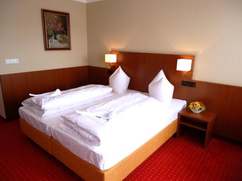 a hotel room with a large bed with white sheets at Hotel Gasthof Posthalter in Zwiesel