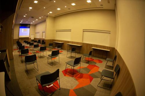a large room with chairs and a projection screen at Novotel Sorocaba in Sorocaba