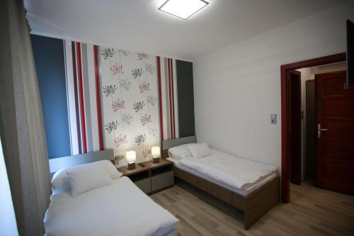 バヤにあるSugó Panzióのベッド2台と窓が備わる小さな客室です。