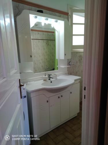 een badkamer met een wastafel en een spiegel bij San Vlassis Area Apartment in Lákones