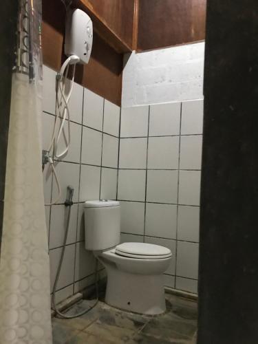a bathroom with a toilet and a phone on the wall at BK Homestay, Batukaras in Batukaras