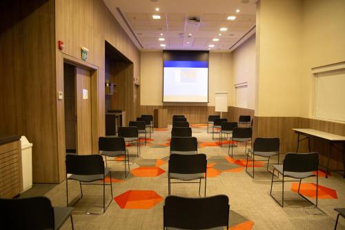 a lecture room with chairs and a projection screen at Novotel Sorocaba in Sorocaba