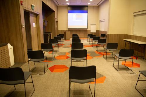 a lecture room with chairs and a projection screen at Novotel Sorocaba in Sorocaba