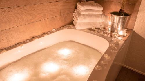 a bath tub in a bathroom with towels on a counter at Wherry Hotel in Lowestoft