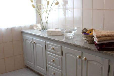 a white bathroom counter with a vase on top of it at Pérola Achadense Guesthouse in Achada