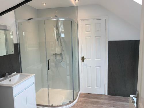 a bathroom with a glass shower and a sink at Fox and Hounds Cottage, Starbotton in Starbotton