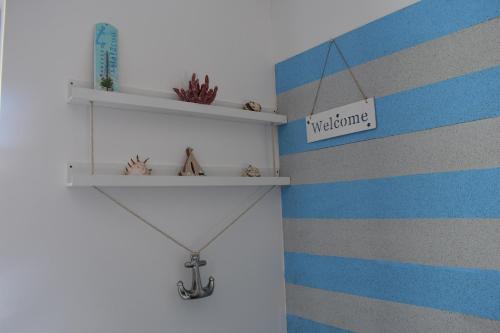 a shelf on a wall with blue and gray stripes at Sziget Vendégház in Szigliget