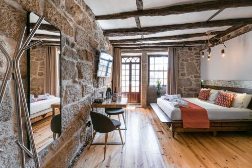 Habitación con 2 camas y pared de piedra. en GuestReady - CastleRock Pub (live music) 1F en Oporto