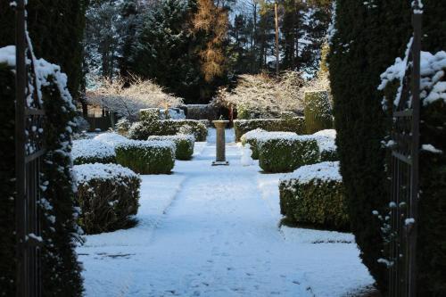 a garden covered in snow with bushes and a fire hydrant at Rufflets St Andrews in St. Andrews