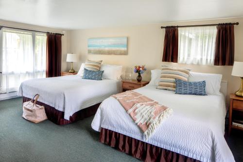 a bedroom with two beds and two windows at Sesuit Harbor House in East Dennis