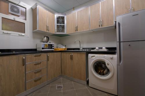 a kitchen with a washing machine and a washer at Downtown Plaza Hotel Apartment Pet Friendly in Abu Dhabi