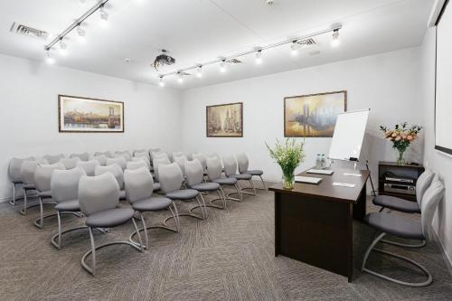 a conference room with chairs and a desk and a podium at Continental Hotel in Odesa