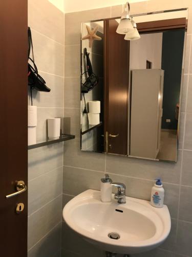y baño con lavabo y espejo. en Casa Marzio Apartments, en Fiumicino