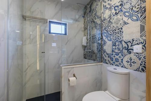 a bathroom with a toilet and a glass shower at Villa Santa Bárbara in Vila Nova de Gaia