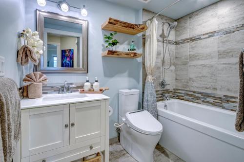 een badkamer met een bad, een toilet en een wastafel bij Sunpath Retreat- Convenience Meets Comfort & Style in Whistler