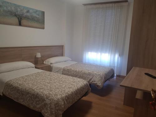 a hotel room with two beds and a window at Hospedaje Norte in Puentedeume