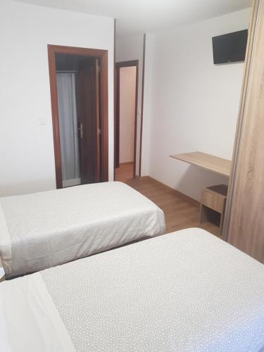 a hotel room with two beds and a mirror at Hospedaje Norte in Puentedeume