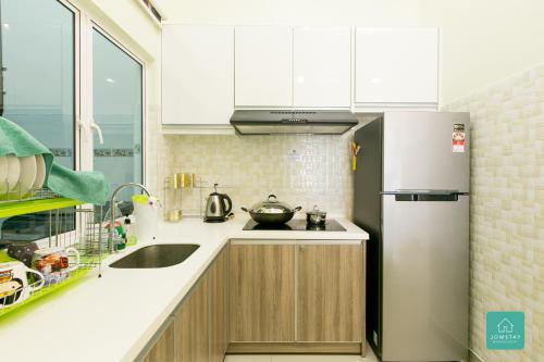 a kitchen with a sink and a refrigerator at JOMSTAY Majestic Ipoh Suites in Ipoh