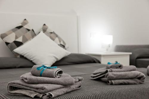 a pile of towels on a bed with a couch at La terrazza dei tramonti in Capaccio-Paestum
