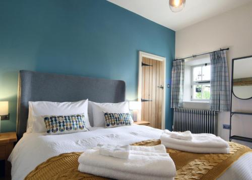 a blue bedroom with a bed with towels on it at Mount Pleasant Cottages in Richmond