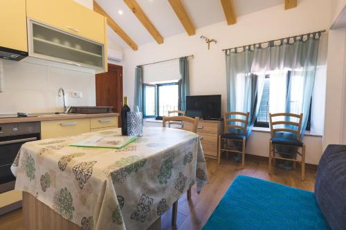 a kitchen and living room with a table and chairs at VINEA APARTMANI UMAG, Ulica G Garibaldia 2 in Umag