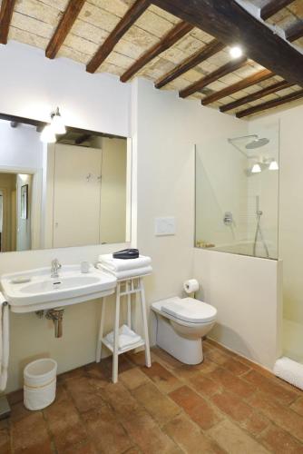 a bathroom with a sink and a toilet and a mirror at Montauto Suites in Chianciano Terme