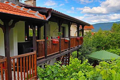 a house with a balcony with flowers on it at GREEN HOUSE - Попниколови in Sapareva Banya