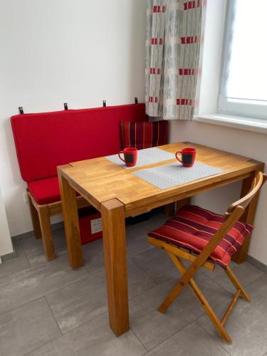 a wooden table and a chair with two cups on it at Haus-Iris-Mauerbach in Mauerbach