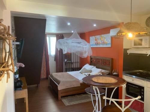 sypialnia z łóżkiem i stołem oraz kuchnia w obiekcie Résidence les 2 MONTOUT w mieście Le Gosier