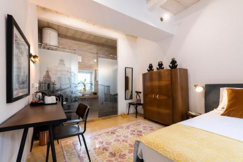 a bedroom with a bed and a desk and a table and chair at 116Townhouse in Rabat