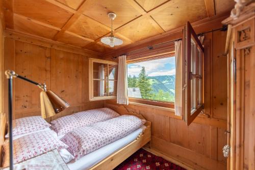 Cette petite chambre comprend 2 lits et une fenêtre. dans l'établissement Villa al Bosco, à Selva di Val Gardena