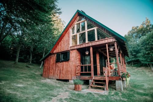a small wooden cabin in the middle of a field at Koliba Šume Pjevaju - robinzonski smjestaj, struja 12 V, voda iz cisterne in Mrkopalj