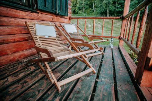 two chairs sitting on the deck of a cabin at Koliba Šume Pjevaju - robinzonski smjestaj, struja 12 V, voda iz cisterne in Mrkopalj
