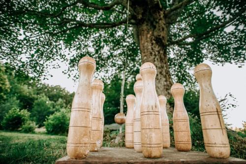 a group of wooden bowling pins lined up next to a tree at Koliba Šume Pjevaju - robinzonski smjestaj, struja 12 V, voda iz cisterne in Mrkopalj