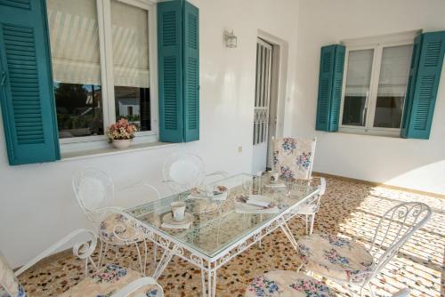 a dining room with a glass table and chairs at Villa Magnolia in Nafplio