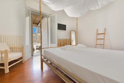 una camera con un grande letto bianco e una sedia di Mimi' Maison by BarbarHouse a Lecce