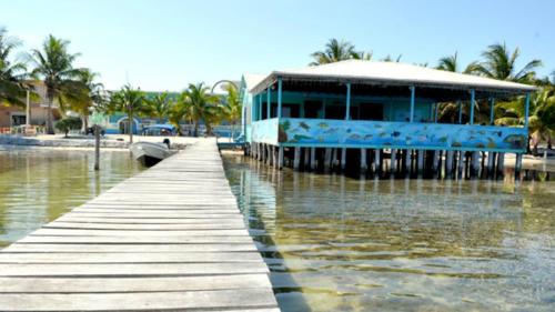 a building on a dock in the water at Rainbow Hotel in Caye Caulker