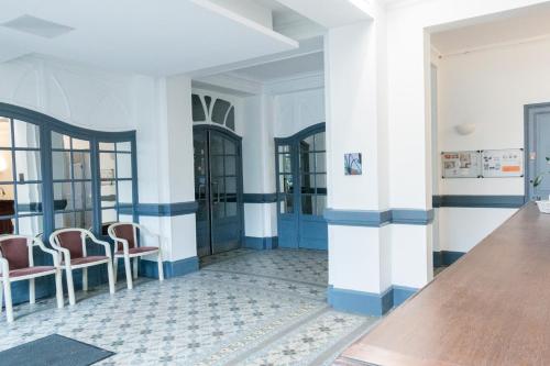 - un hall d'un immeuble avec des murs et des chaises bleus et blancs dans l'établissement Le Gérémoy, à Vittel