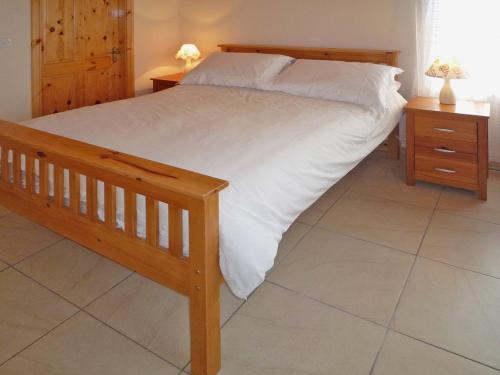 a bedroom with a large bed and two night stands at Timmys Cottage Heir Island by Trident Holiday Homes in Skibbereen