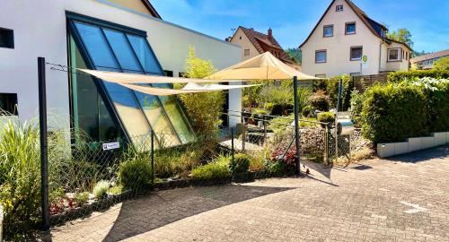 a fence with aige umbrella in front of a building at LIVE-IN Wertheim am Main in Wertheim