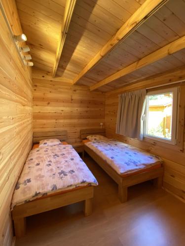 a room with two beds in a log cabin at Camping Piccolo Paradiso in Avegno