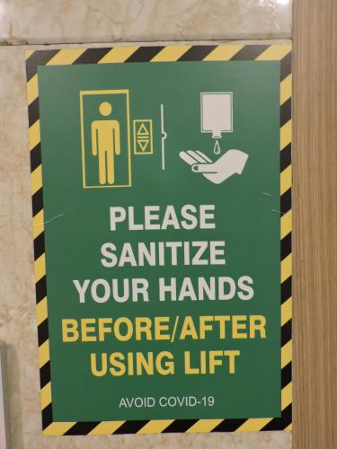 a sign that reads pleaseennaattle your hands before using lift at Le Roi Digha in Digha