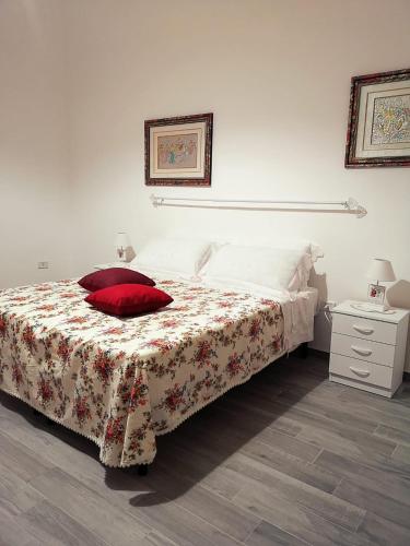 Un dormitorio con una cama con una almohada roja. en A Casa di Santé, en Arnesano