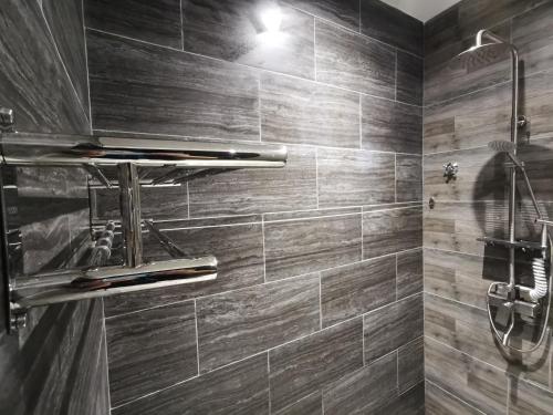 a bathroom with a shower with wooden tiles at Foresight Hotel in Tawau