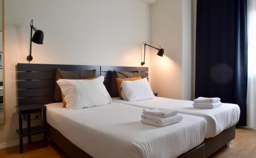 a bedroom with two beds with white sheets and pillows at Spot Apartments in Porto