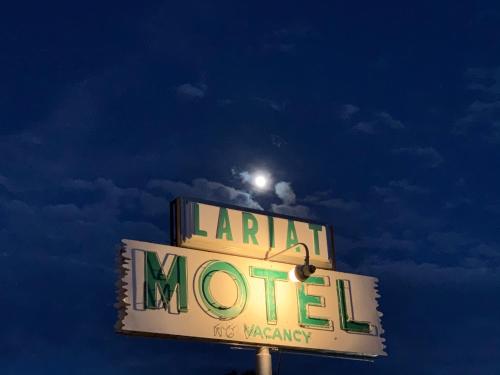 a sign for a motel with a light on top at Lariat Motel in Moriarty